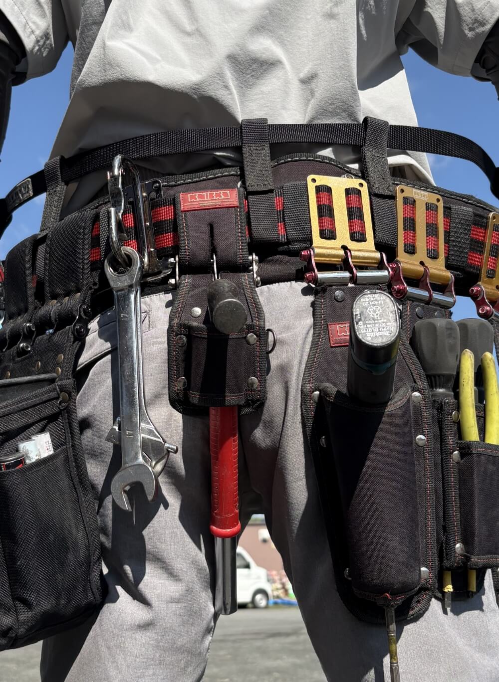 スパナやドライバーなどの工具を装着した電工ベルト姿の作業員